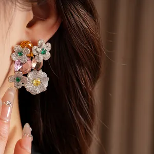Close-up of vintage flower stud earrings with colorful crystals and zircons