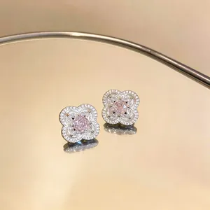 Dettagliata macro di eleganti orecchini a lobo a fiore con pietra centrale rosa a rosa