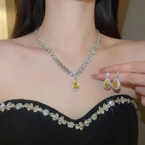 Elegant jewelry set with teardrop yellow zircon necklace and matching earrings on model