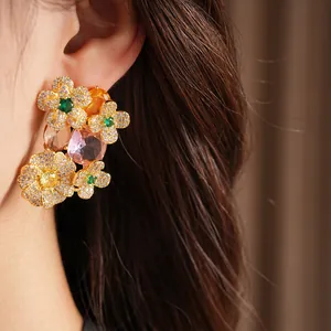 Close-up of vintage floral zircon earrings with colorful gemstones worn on ear
