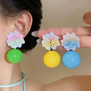Detailed macro view of colorful resin floral earrings with large vibrant round beads.