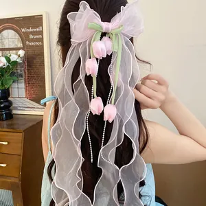 Vista dettagliata del fermaglio per capelli a fiocco in tulle rosa con ciondoli a tulipano