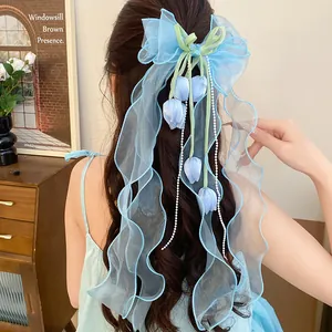 Dettaglio posteriore di un fermaglio per capelli a fiocco azzurro con volant e fiori