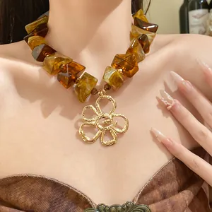 Close-up of a vintage Maillard style necklace with brown acrylic beads and gold flower.