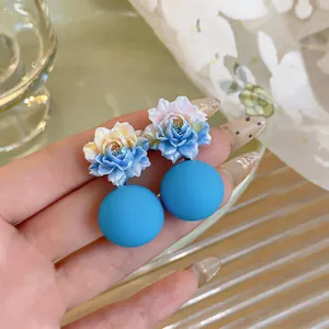 Close-up of blue resin flower earrings with large matte round pendants for women