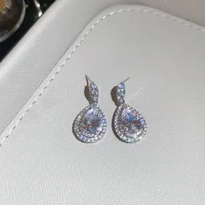 Close-up of luxurious pear-shaped zircon earrings with sparkling silver finish.