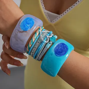 Detailed view of layered blue leather bracelet with heart charm and resin bangles
