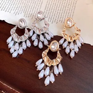 Elegant vintage-style rhinestone and pearl tassel drop earrings with ornate oval design