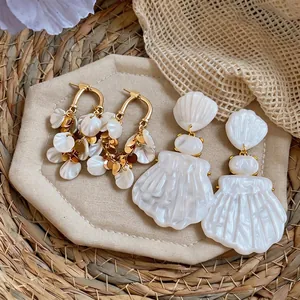 French style elegant shell dangle earrings and golden tassel drop earrings on straw mat
