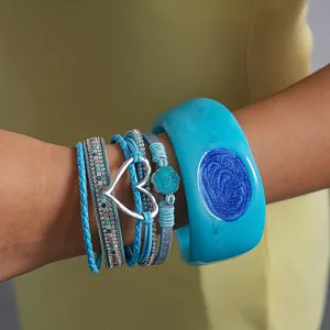 Close-up view of bohemian blue resin bangle and multi-layer heart leather bracelet set