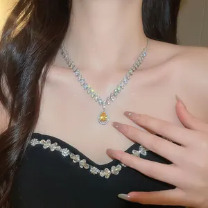 Detailed close-up of a luxurious teardrop yellow zircon necklace worn on a model's neckline