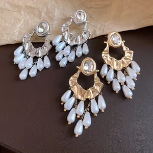 Close-up of luxury vintage gold and silver tassel earrings with pearls and crystals