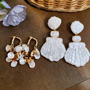 Detailed view of French vintage style white pearl tassel and shell resin earrings