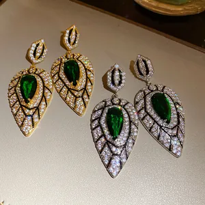 Details von eleganten Tropfen-Ohrringen mit grünen Zirkoniasteinen in Gold und Silber