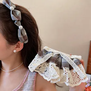 Détail d'un nœud à cheveux en tissu à carreaux bleus avec dentelle et perles fines