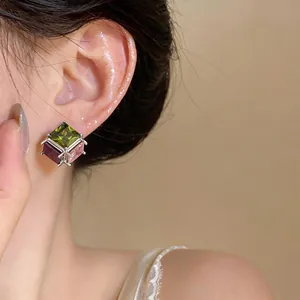 Close-up of elegant square stud earrings with multi-color cubic zirconia on model