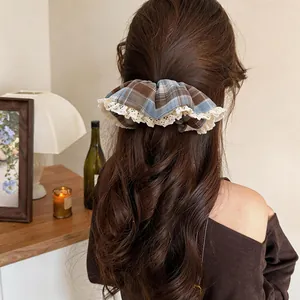 Pince à cheveux élégante en tissu à carreaux bleus avec bordure en dentelle sur cheveux bruns