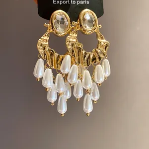 Close-up of vintage gold earrings with clear crystals and pearl tassels