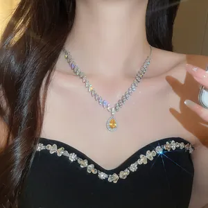 Macro shot of a yellow water drop zircon necklace on model's neck for a luxury look.