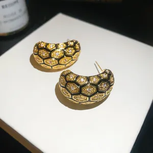 Close-up of vintage 18k gold-plated honeycomb grid earrings with zircon inlay