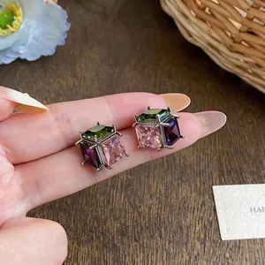 Close-up view of elegant square stud earrings featuring sparkling multicolored zircon gemstones