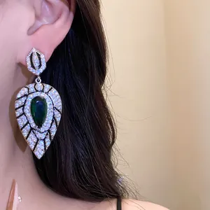 Elegante Tropfenohrringe mit grünem Zirkon und Kristalldetails aus nächster Nähe.