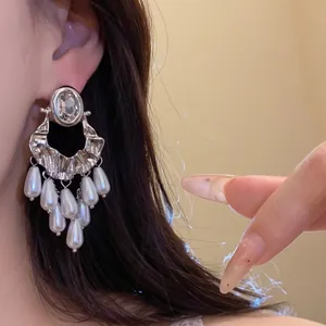 Detail view of vintage style silver tassel earrings with elegant white pearls and crystals