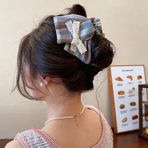 Gros plan d'un nœud à cheveux à carreaux bleus avec dentelle sur un chignon