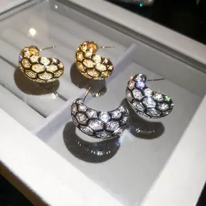 Macro detail of 18k gold plated honeycomb earrings with sparkling zirconia stones.