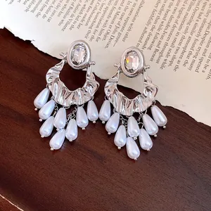 Vintage silver earrings featuring an oval rhinestone and cascading white pearl tassels