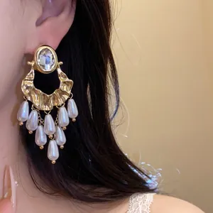 Detailed view of vintage gold chandelier earrings with crystal and pearl tassels
