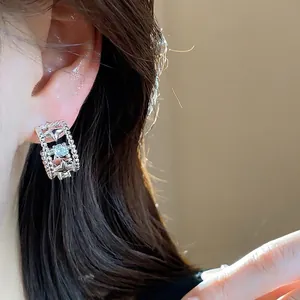 Eleganti orecchini a perno a stella geometrica in argento con un brillante zircone