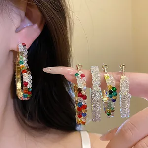 Close-up of stylish hoop earrings decorated with vibrant colorful and clear glass beads