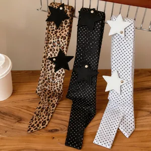 Detailed view of trendy leopard and polka dot scarves with leather star patches and pearls.