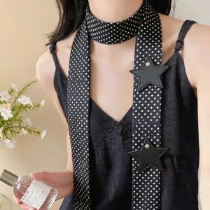 Detailed view of trendy black polka dot skinny scarf with leather star patchwork accents.