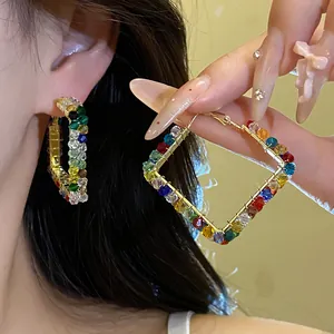 Close-up of colorful faceted glass bead square hoop earrings with gold-tone finish