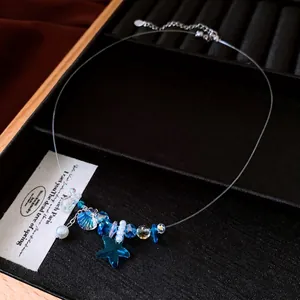 Collana con ciondolo a stella marina e perla con cristalli blu su un filo trasparente