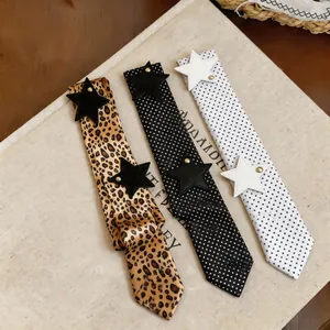 Detailed close-up of leopard and polka dot scarves with leather star patchwork details