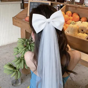 Detailed back view of white fabric bow hair clip with an elegant long mesh veil accessory