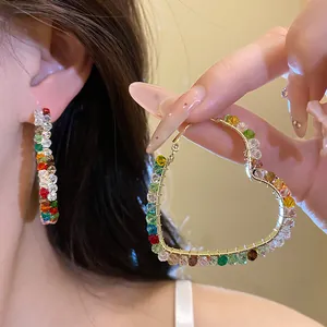 Close-up of elegant heart-shaped hoop earrings decorated with vibrant colorful glass beads
