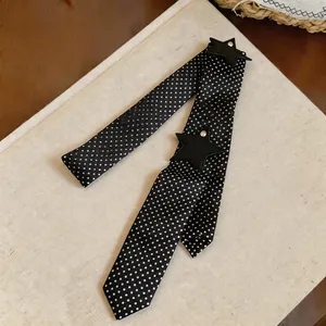 Close-up of polka dot scarf tie with leather star patches and rhinestone detail
