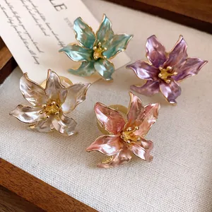 Detail view of four vintage enamel tulip flower rings in mint, pink, white, and purple.