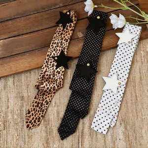 Close-up showing three stylish long scarves with leopard print and polka dot designs