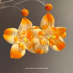 Romantic orange fabric flower drop earrings with raffia accents for beach vacation style