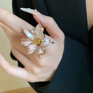 Close-up detail of a vintage pearlescent tulip flower ring with gold edges on hand