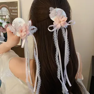 Detail van schattige stoffen bloem en strass vlinder kwast haarclip gedragen in haar.