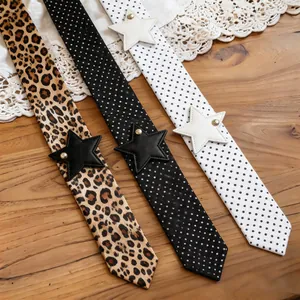 Close-up detail of leopard and polka dot silk scarves with faux leather star patches.
