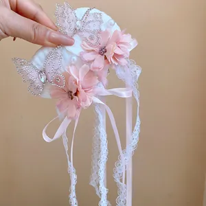 Detailopname van roze stoffen bloemen en strass vlinderdetails op de haarklem set