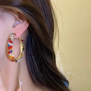 Detail shot of elegant silver needle hoop earring with vibrant multi-colored glass beads