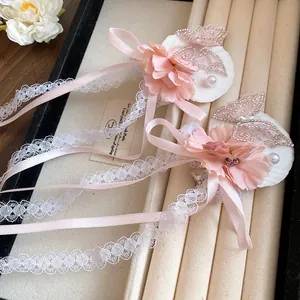 Gedetailleerd overzicht van roze bloemen haarclips met vlinders van strass en linten.